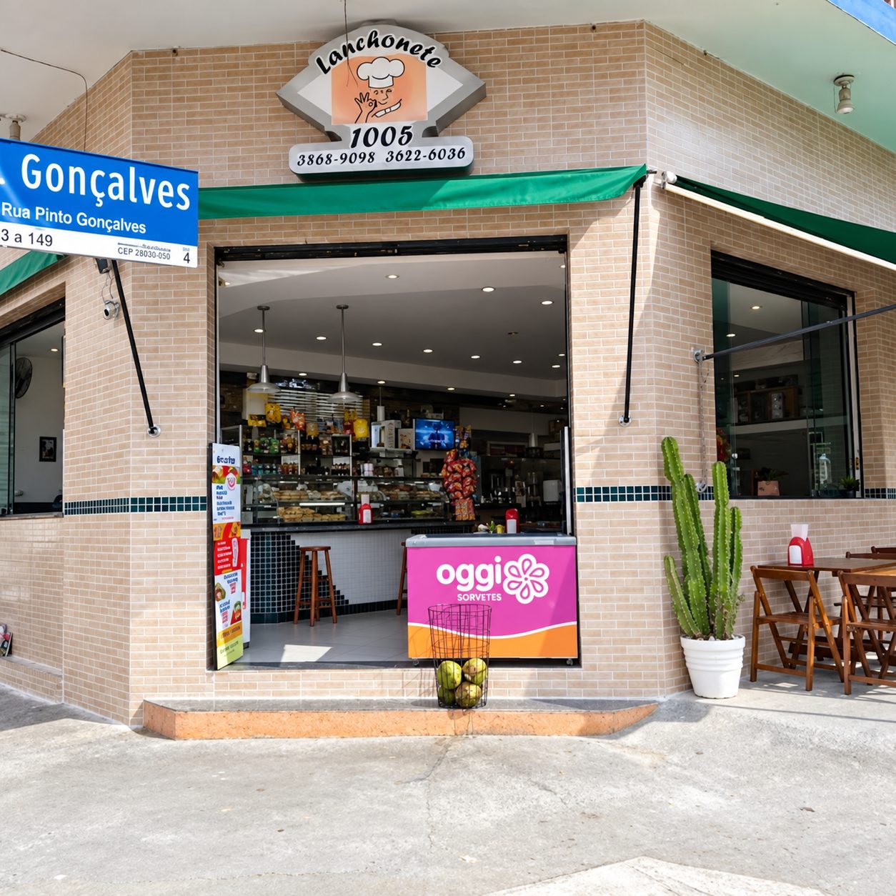 Fachada da Lanchonete 1005 na esquina, com toldo verde e mesas na calçada